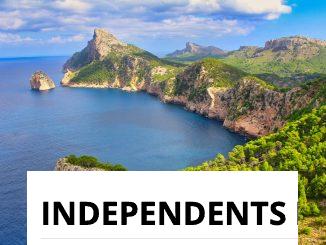 green and brown mountain beside blue sea under blue sky during daytime