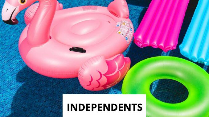 Bright inflatable flamingo and rings floating in a sunny pool.